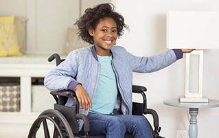 Девушка в инвалидной коляске включает лампу
