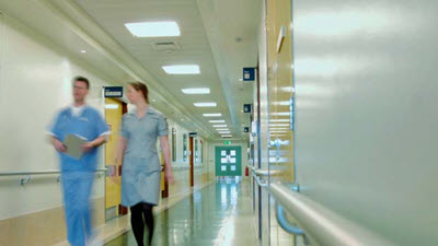nurse and volunteer walking in hospital hallway